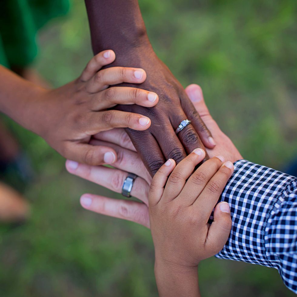 volunteers join hands after conducting a free healthcare clinic for an undeserved area funded by a nonprofit grant